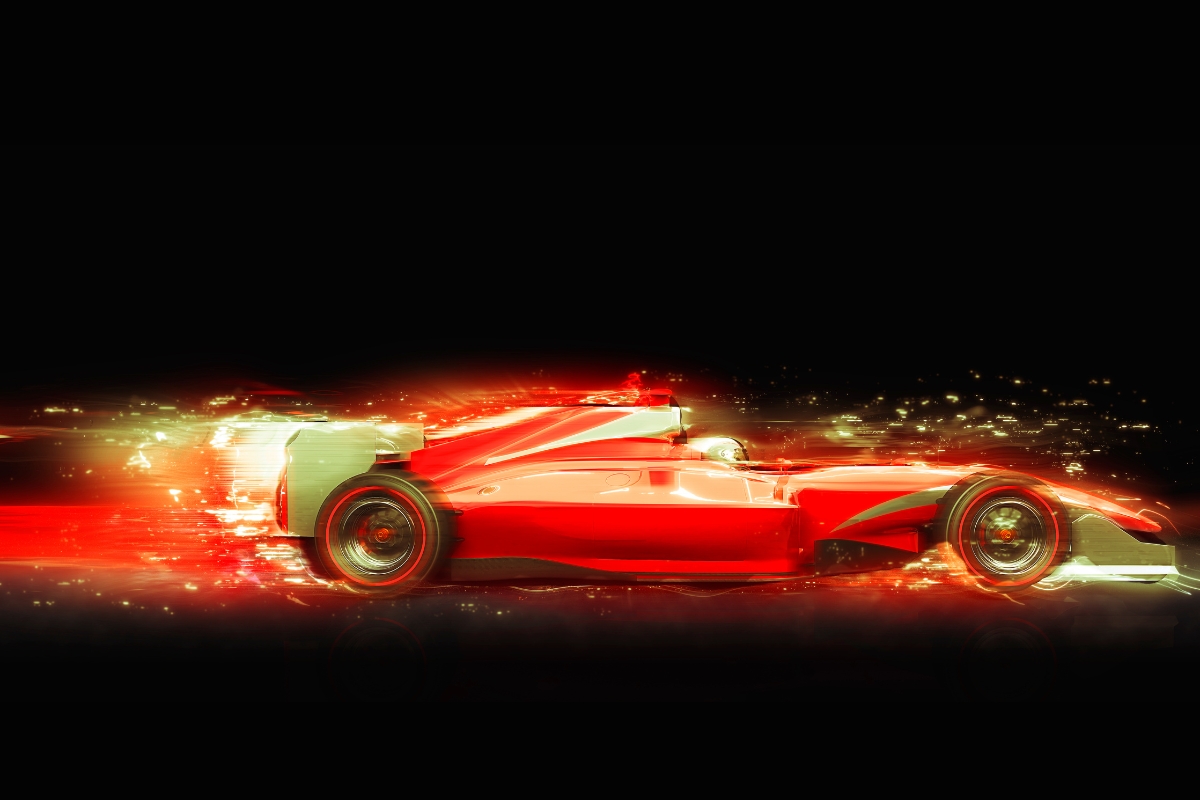 Red car racing against a black background